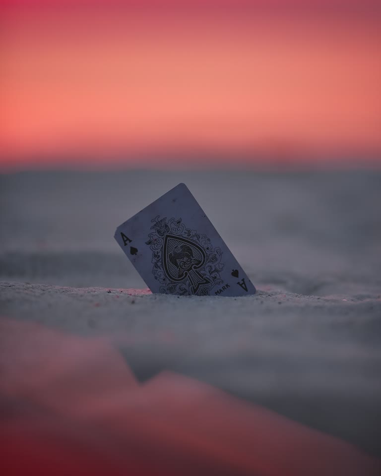 沙滩上的沙子里卡着一张扑克牌